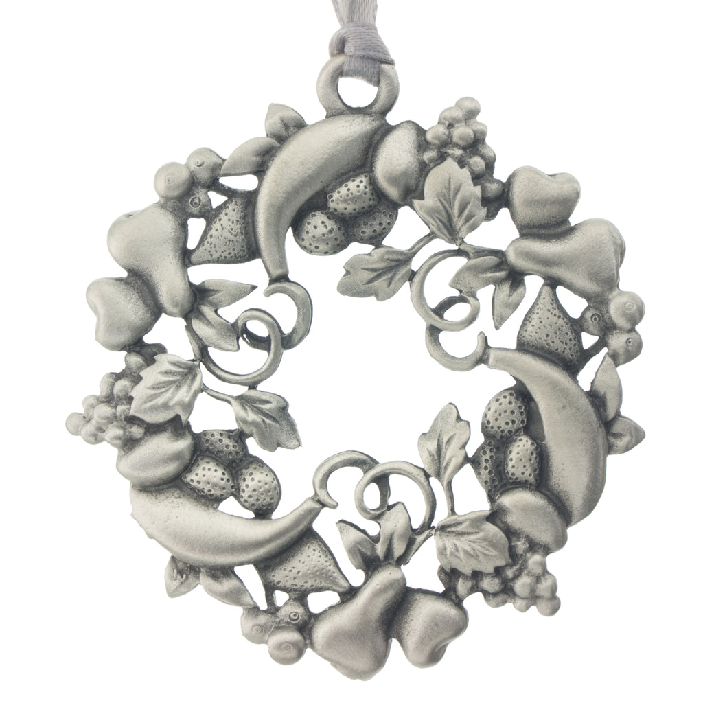A holiday wreath fashioned from festive fruits. Christmas Tree ornament. Made from Pewter. Silver ribbon. Made in Fredericton NB New Brunswick Canada