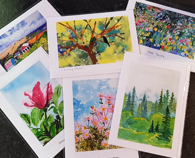 Watercolour art cards laid out on a table