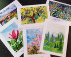 Watercolour art cards laid out on a table
