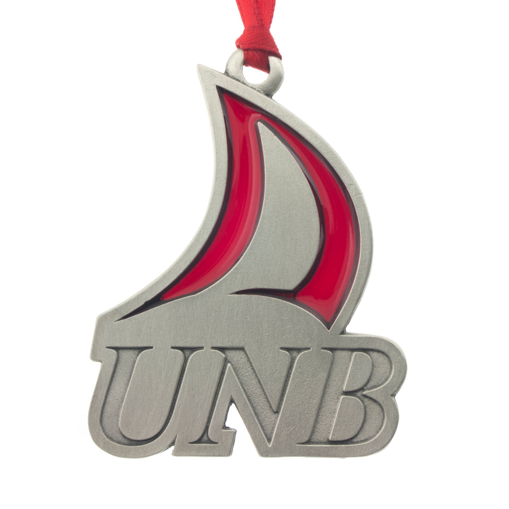The UNB Logo with a handsome translucent red enamal embellishment. Christmas Tree ornament. Made from Pewter. Red ribbon. Made in Fredericton NB New Brunswick Canada
